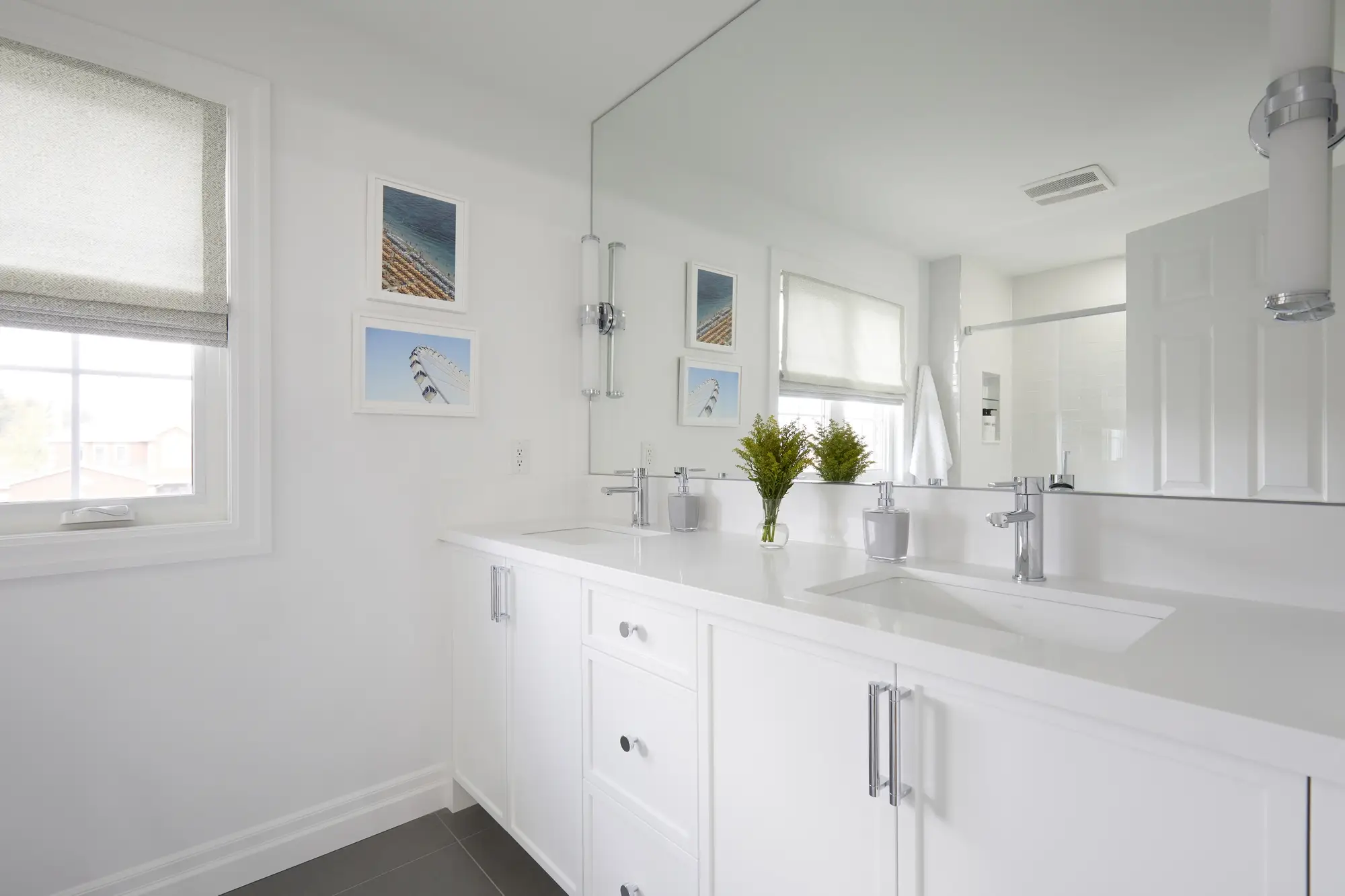 A bathroom with a large soaking tub, marble tile, and a modern vanity with ample storage.