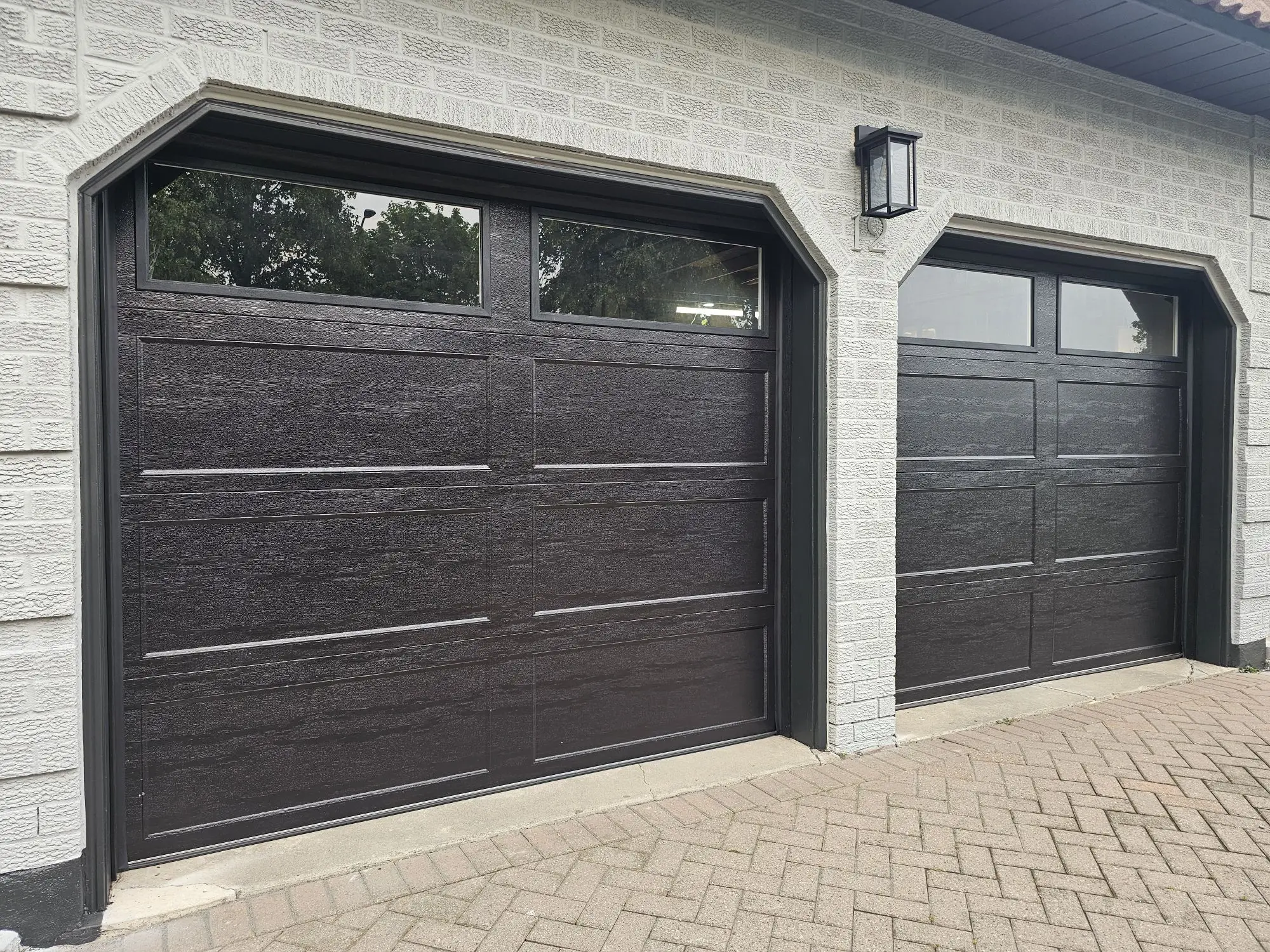 A modern insulated garage door installed on a contemporary home, featuring clean lines, durable panels, and a quiet, smooth operating opener system.