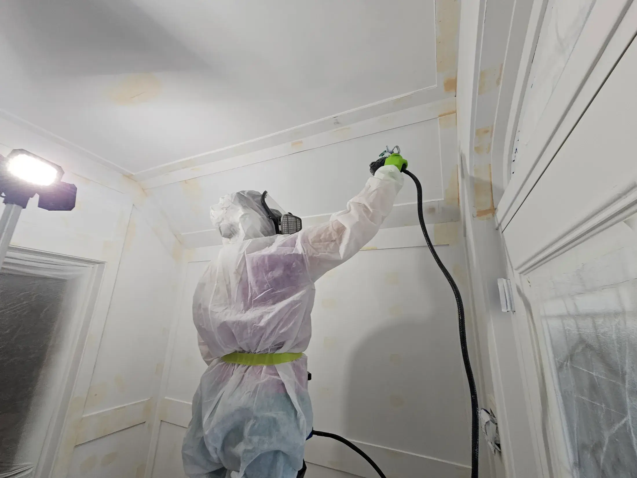 Protected interior spray painting process with masking and controlled application.