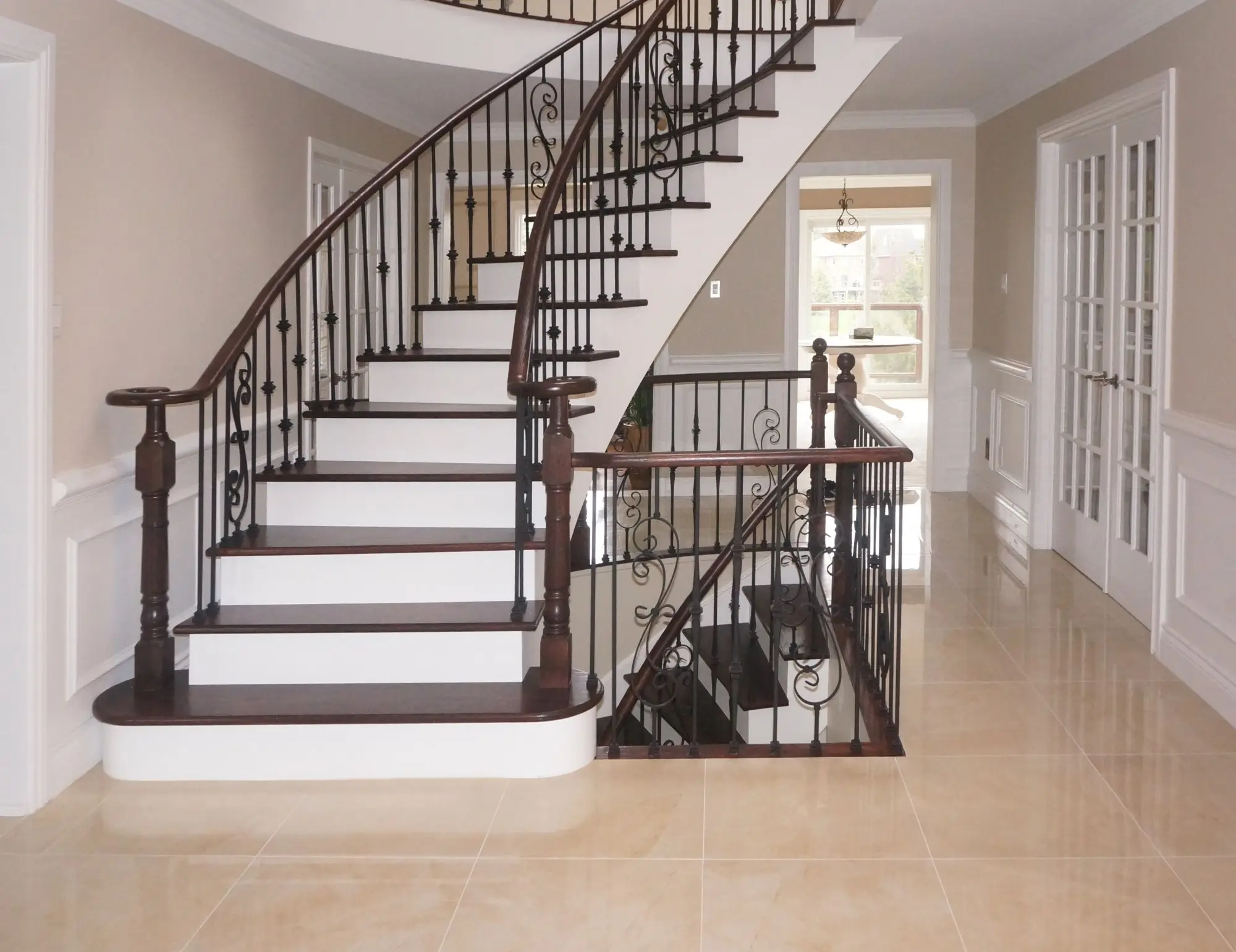 Updated staircase after stair railing installation in King City with black balusters and wood handrail.