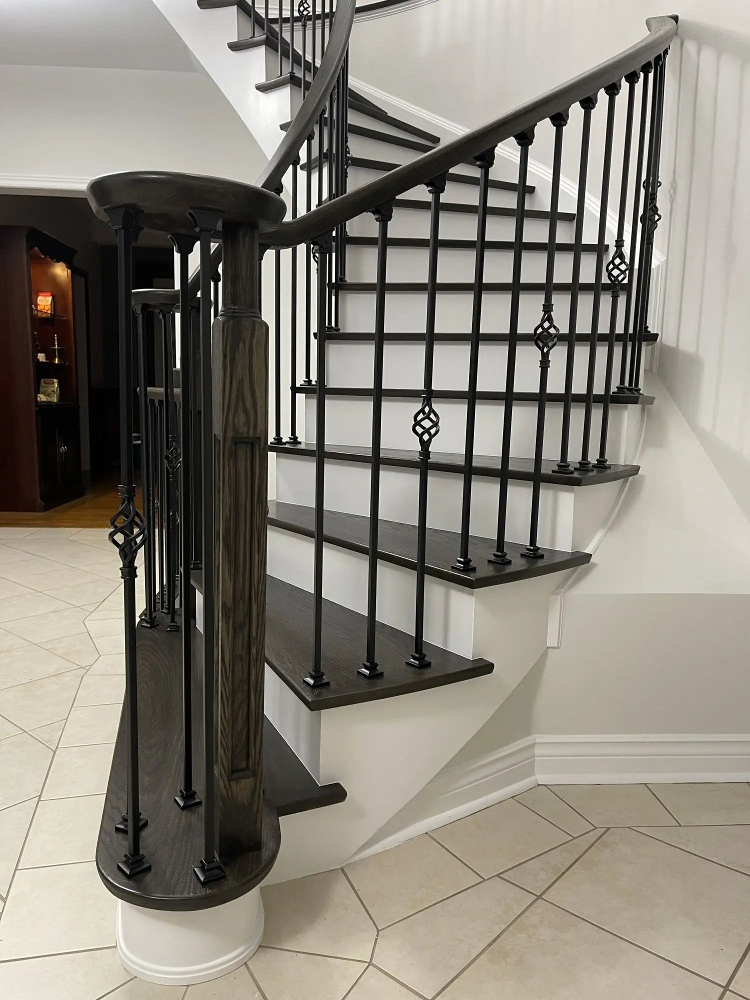 Stair railing installation in Toronto with black balusters.