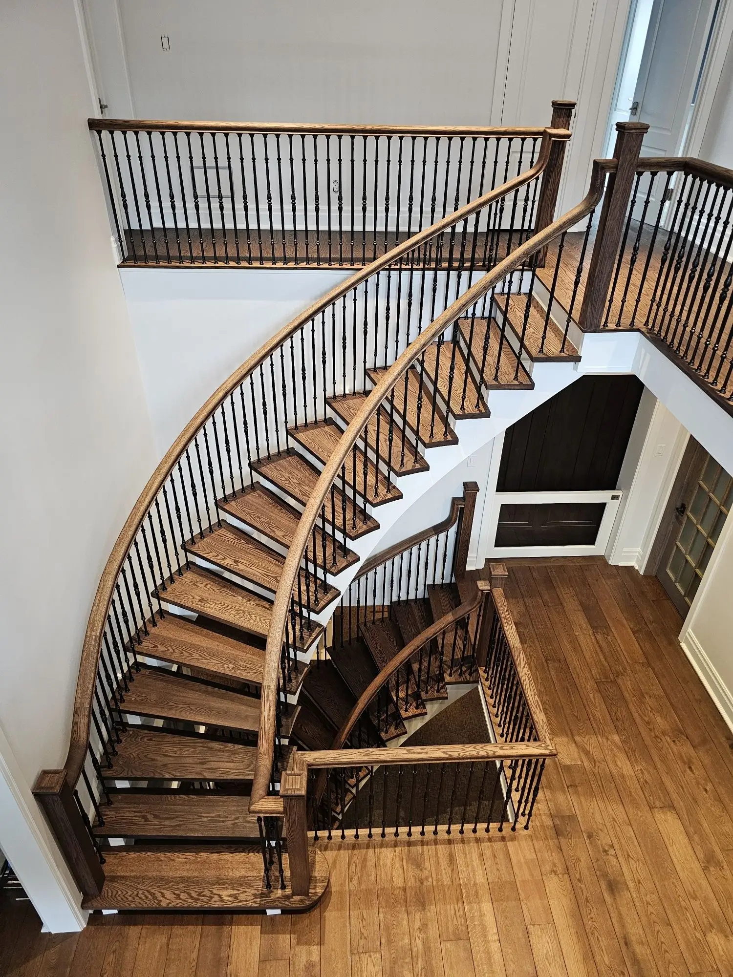 Wide angle view of curved staircase refinishing.