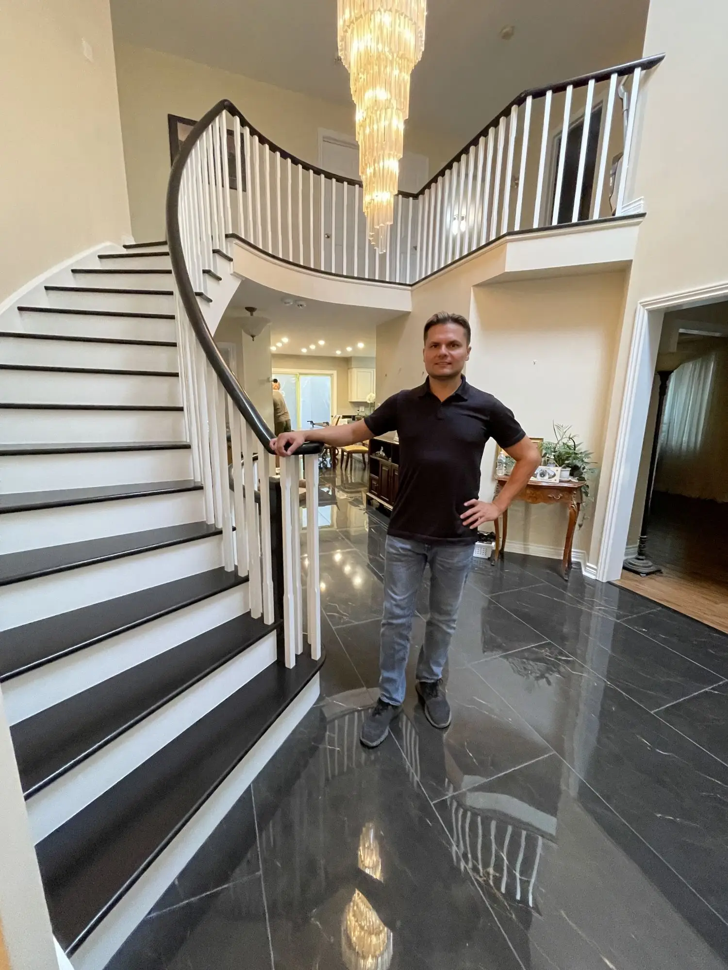 Grand curved staircase refinishing in a luxury foyer.