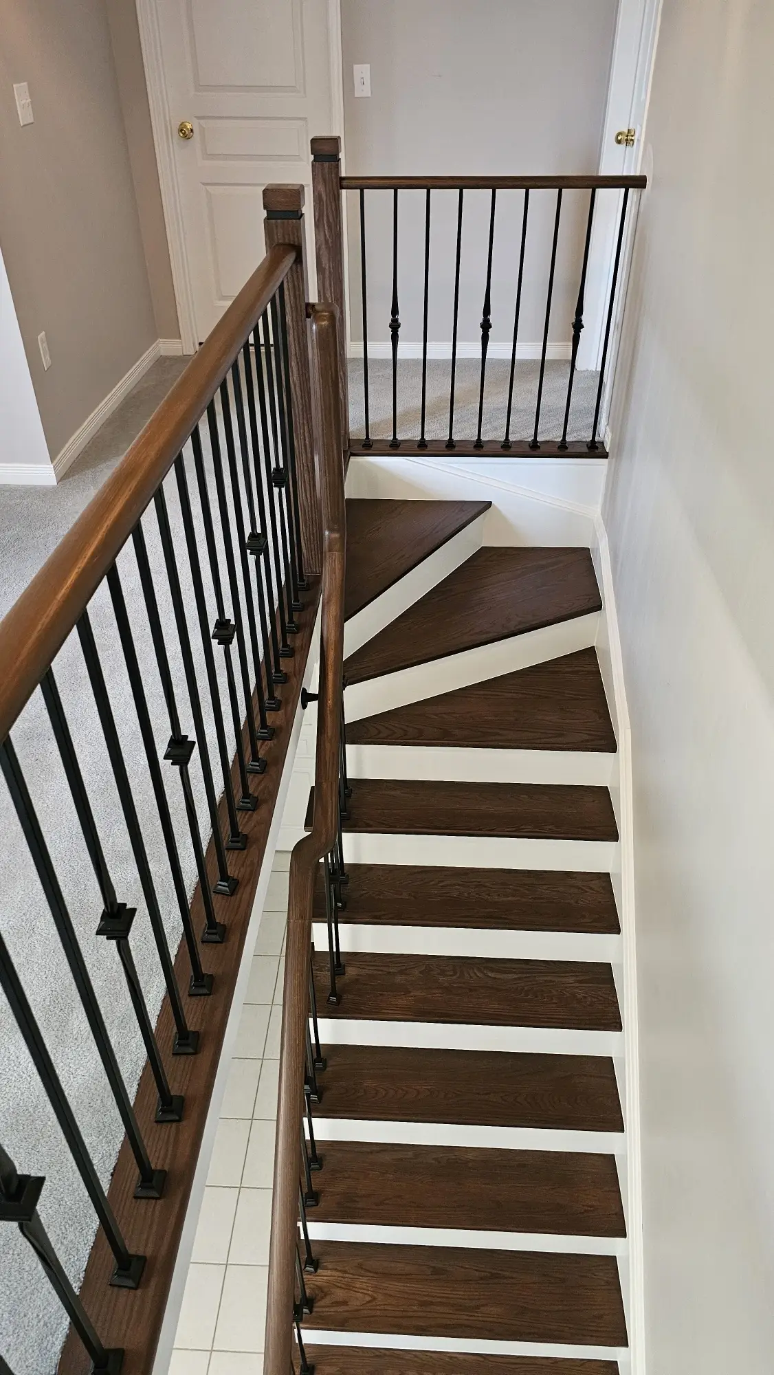 Staircase refinishing in Vaughan with wood treads and iron balusters.