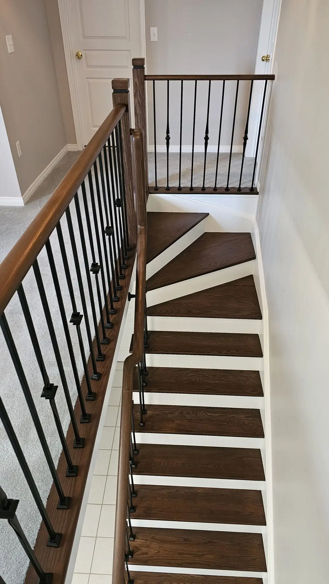 Staircase refinishing in Vaughan with wood treads and iron balusters.