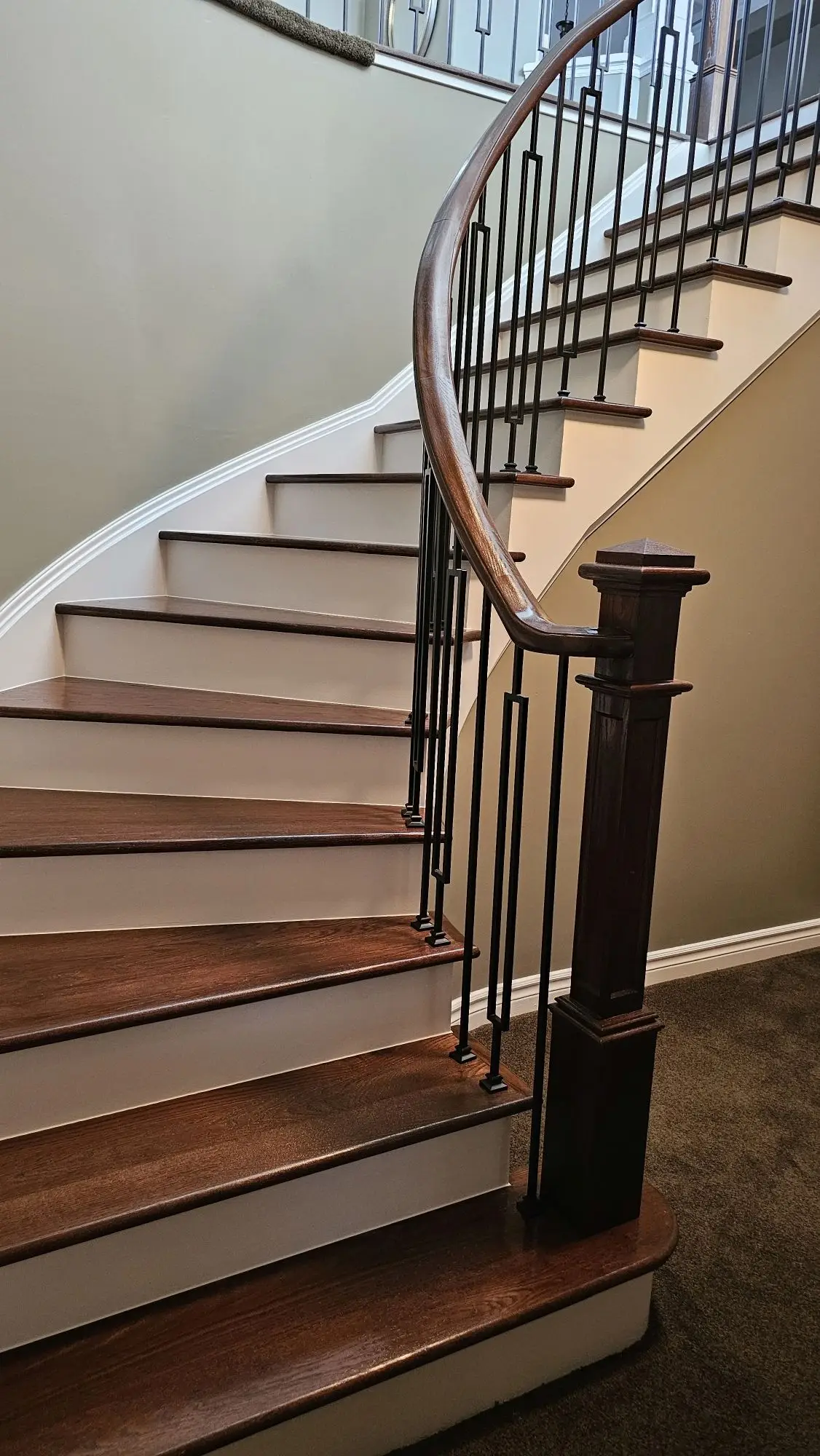 Modernized staircase renovation in Vaughan with dark wood finish and black railing.
