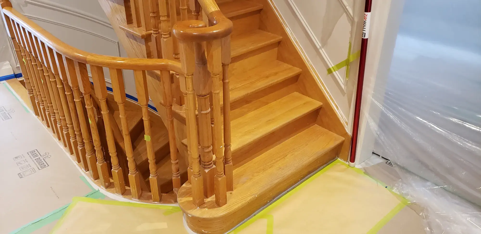 Woodbridge staircase before refinishing with natural oak treads, posts and wood spindles.