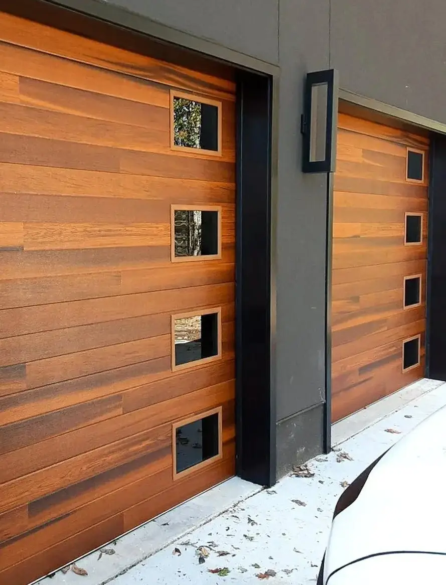 A modern insulated garage door in sleek white panels on a suburban home.