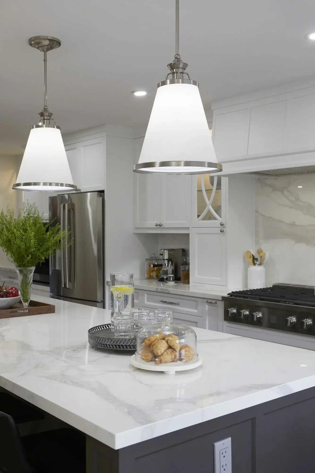 White kitchen with centre island, pendant lighting, quartz counters, and black island seating in King City.
