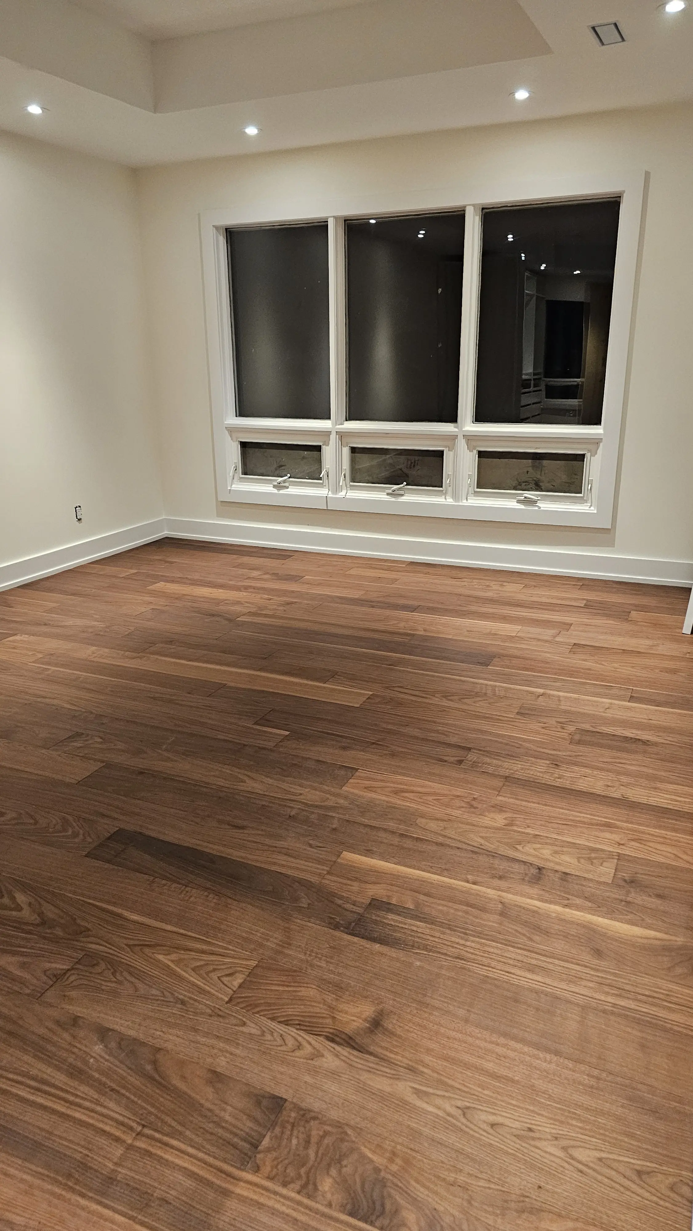 Dark hardwood hallway flooring with clean baseboards and doorway transitions.