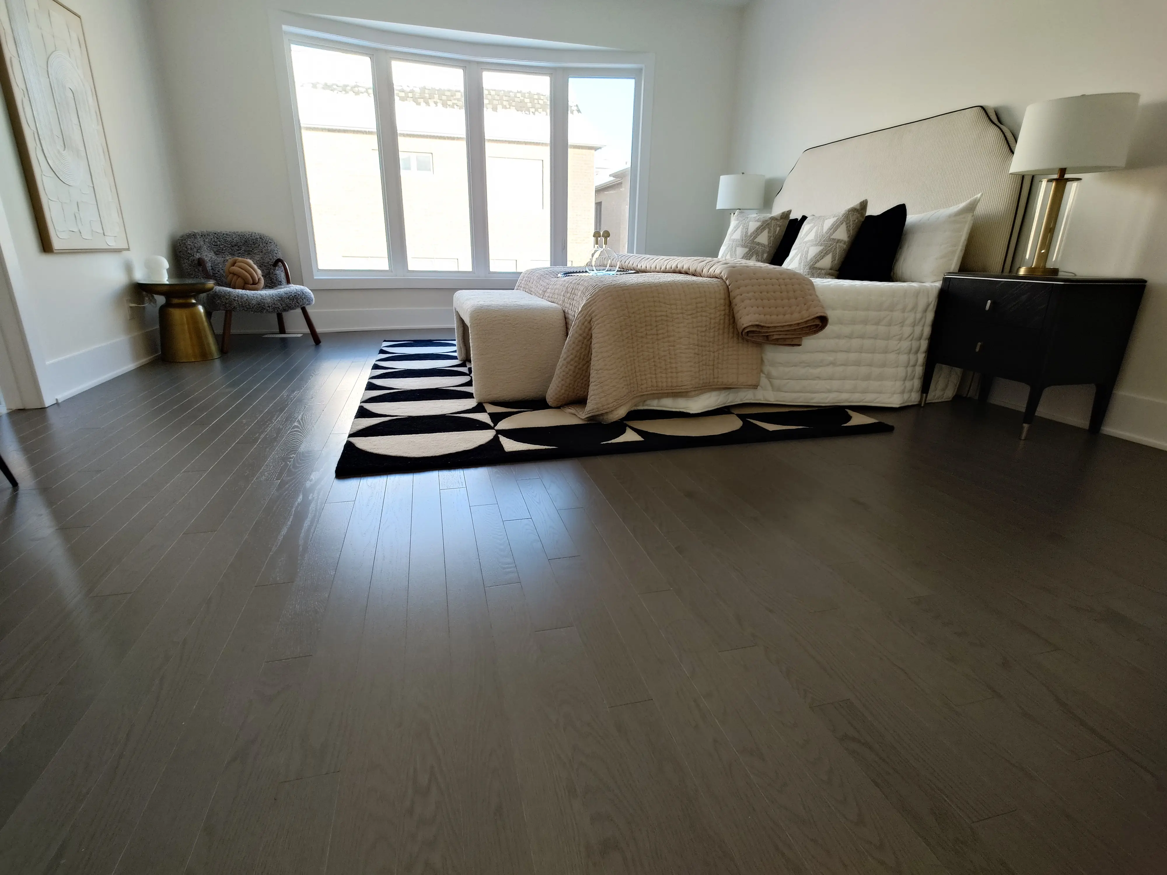 Dark wide plank hardwood flooring installed through a finished living room with clean baseboards.