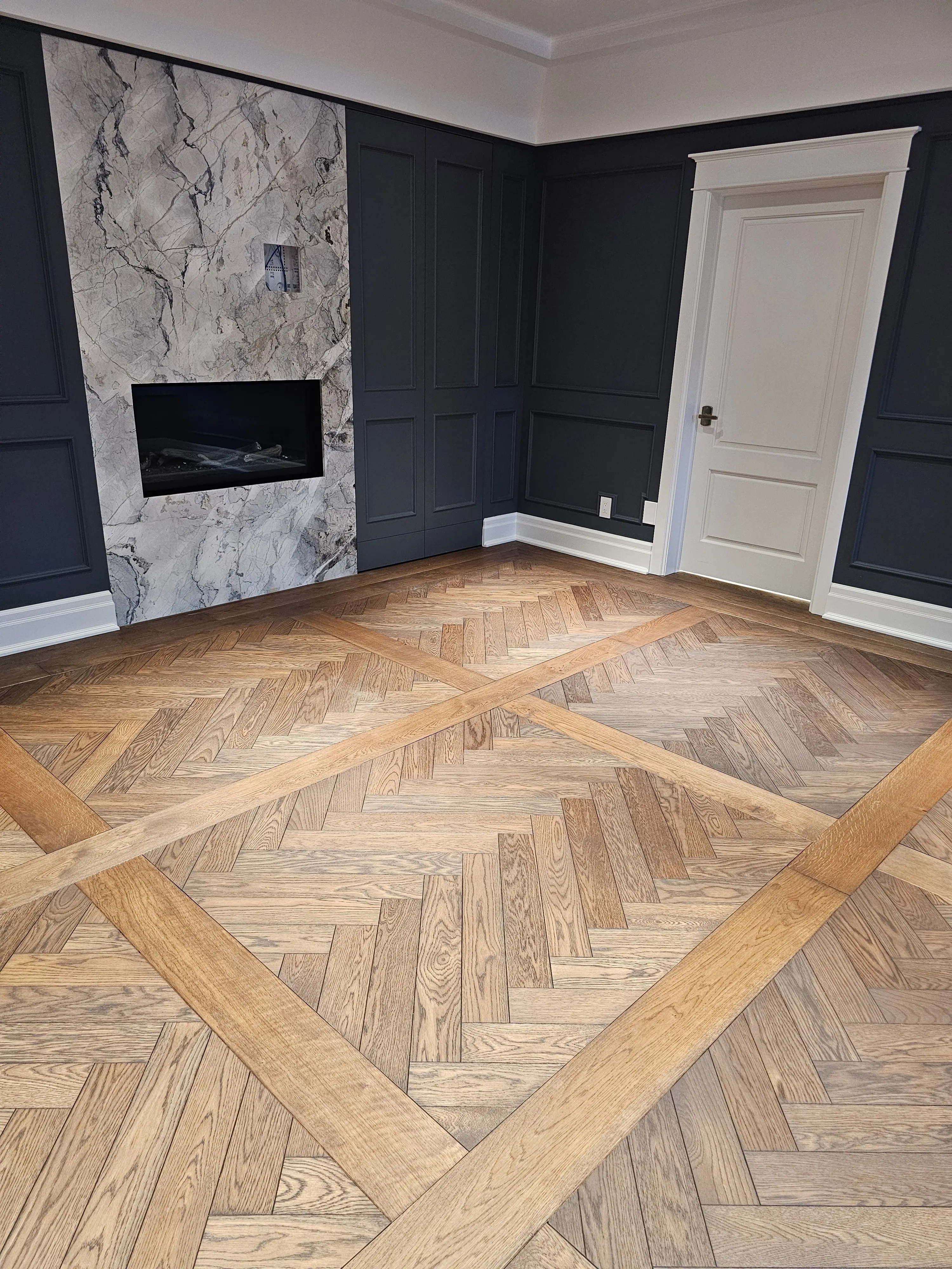 Herringbone hardwood flooring border installation detail.