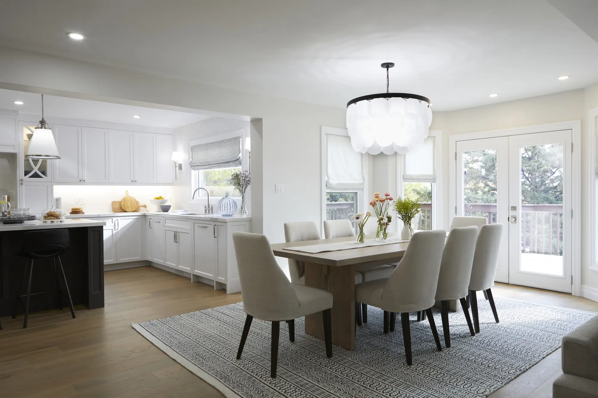Light oak flooring through a dining room and kitchen with bright finished interior details.