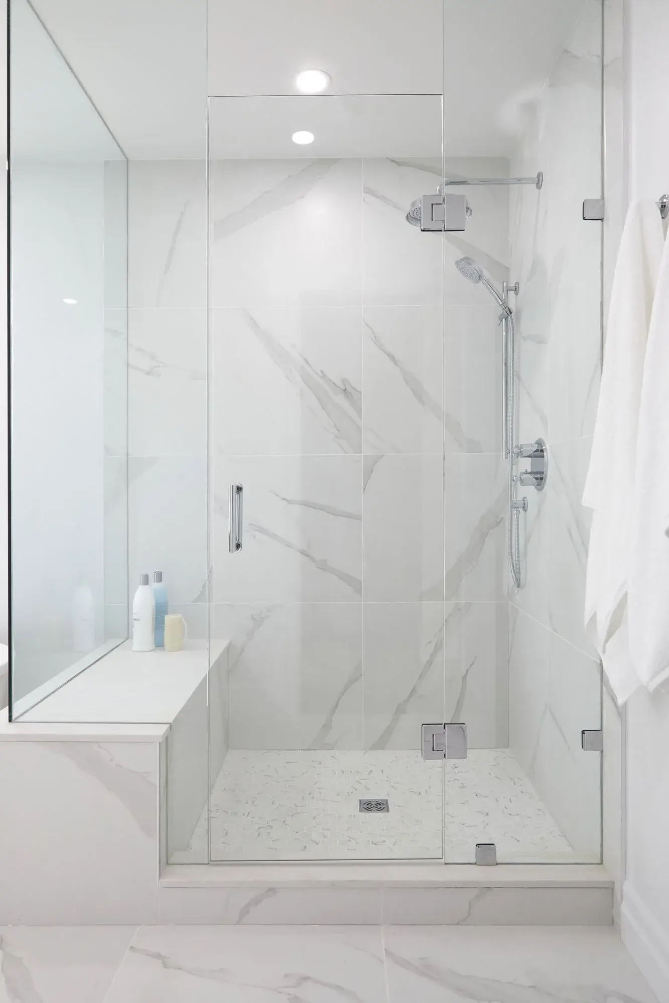 Marble glass shower bathroom renovation with frameless shower door, recessed lighting, and large format tile in Vaughan.