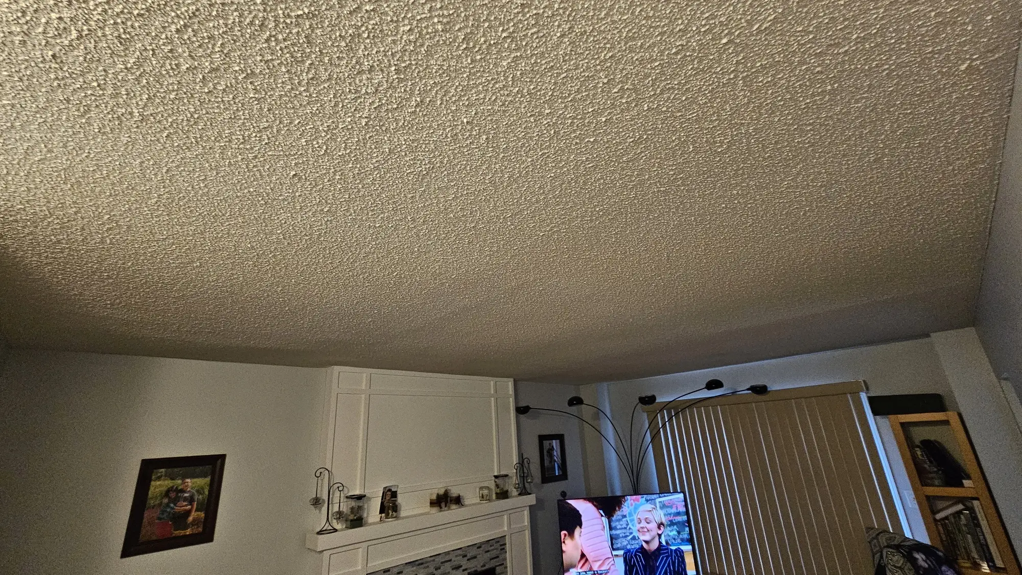 A protected room prepared for ceiling refinishing, with furniture and fixtures carefully covered to ensure a dust-free renovation process.