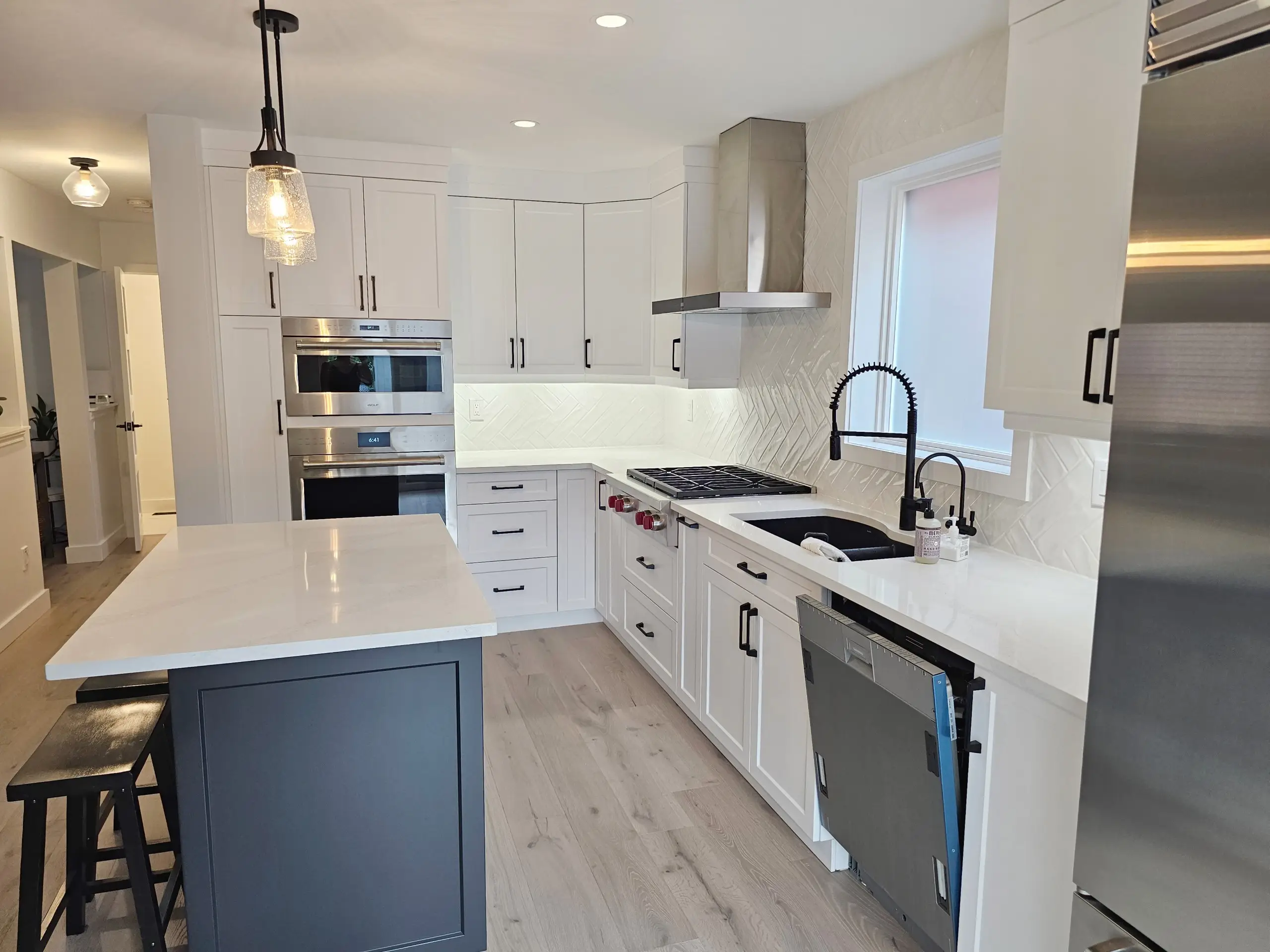 A contemporary kitchen with dark cabinets, under-cabinet lighting, and built-in appliances.