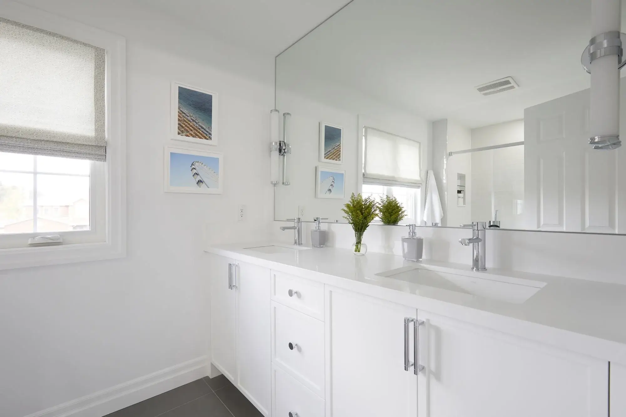 White double vanity bathroom renovation with two sinks, chrome fixtures, wall mirrors, and clean storage layout in Toronto.