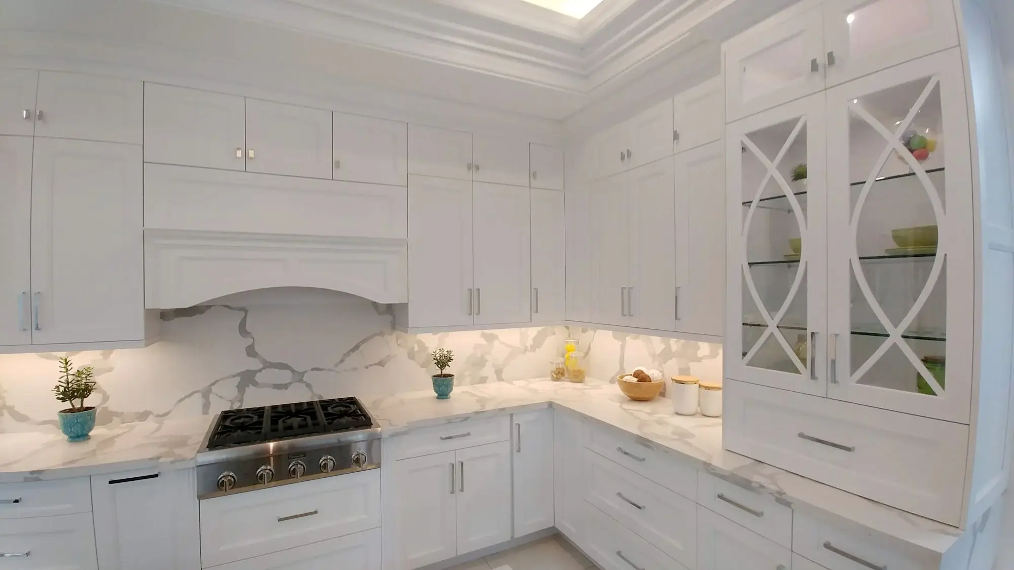 White kitchen cabinets with grey-vein quartz countertop and clean modern renovation finish in Toronto.
