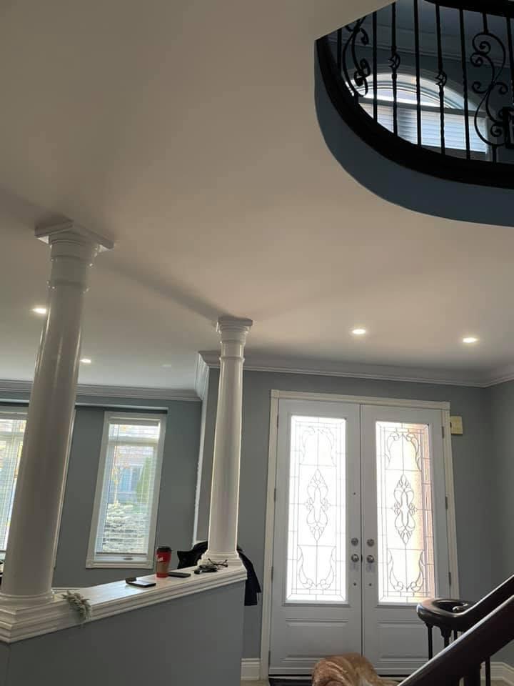 Finished foyer with smooth ceilings, recessed pot lights, painted columns and crown moulding.