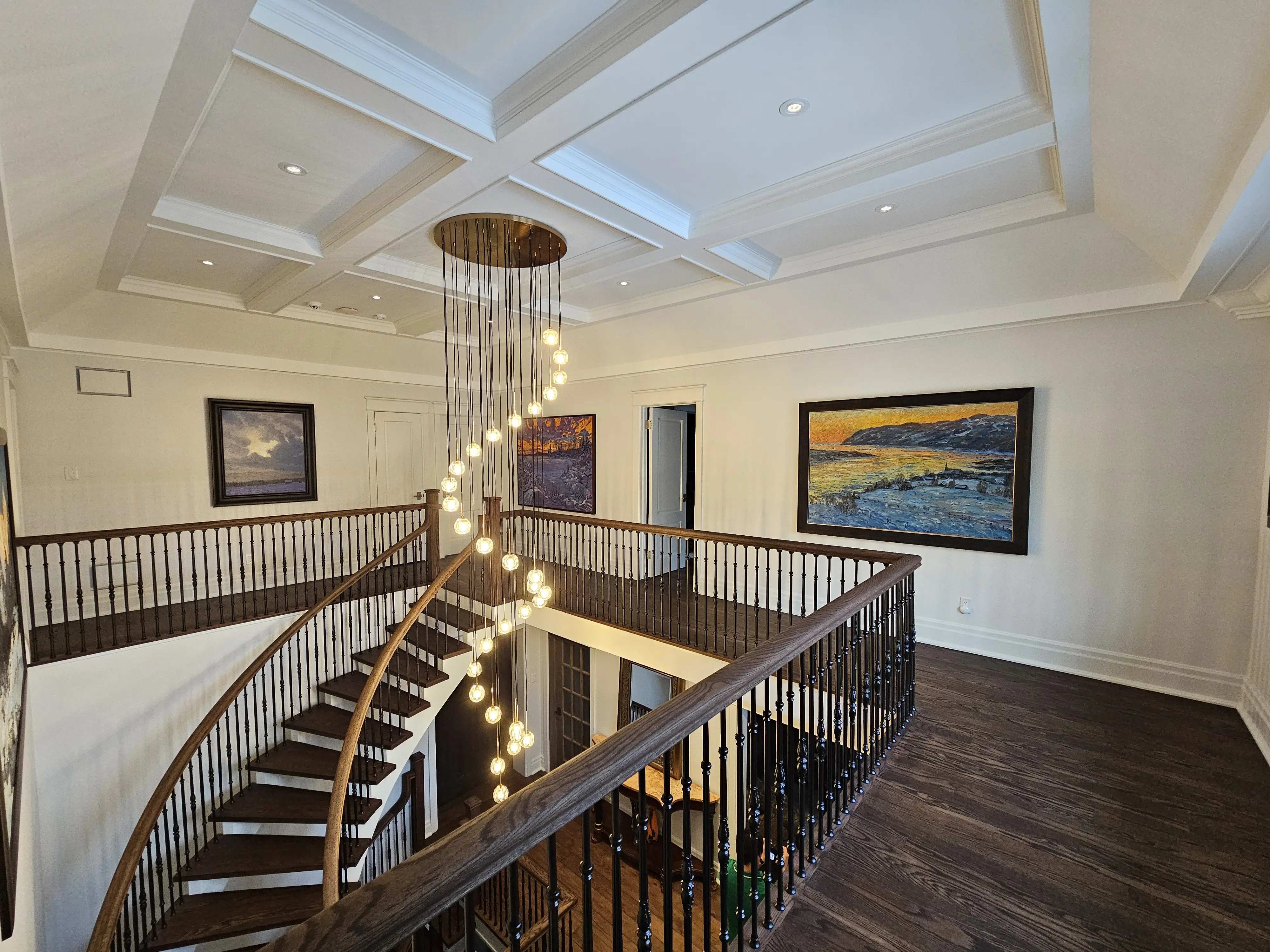 A beautifully renovated open space featuring elegant hardwood floors, decorative iron railings, and bright natural light highlighting the cozy living area and stylish decor.