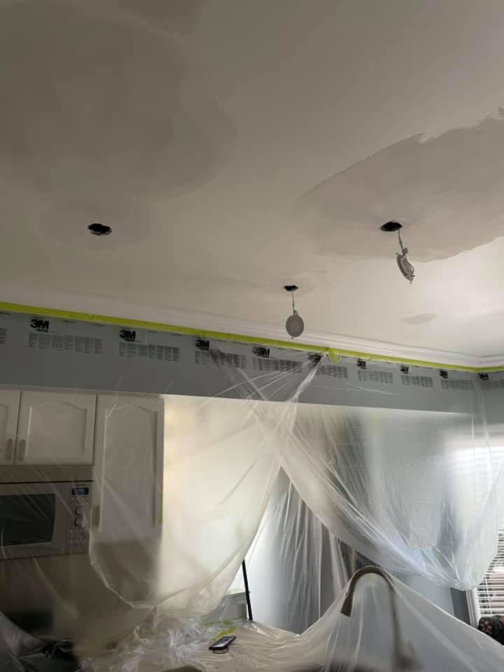 Patched electrical access openings blended into a skim-coated ceiling.