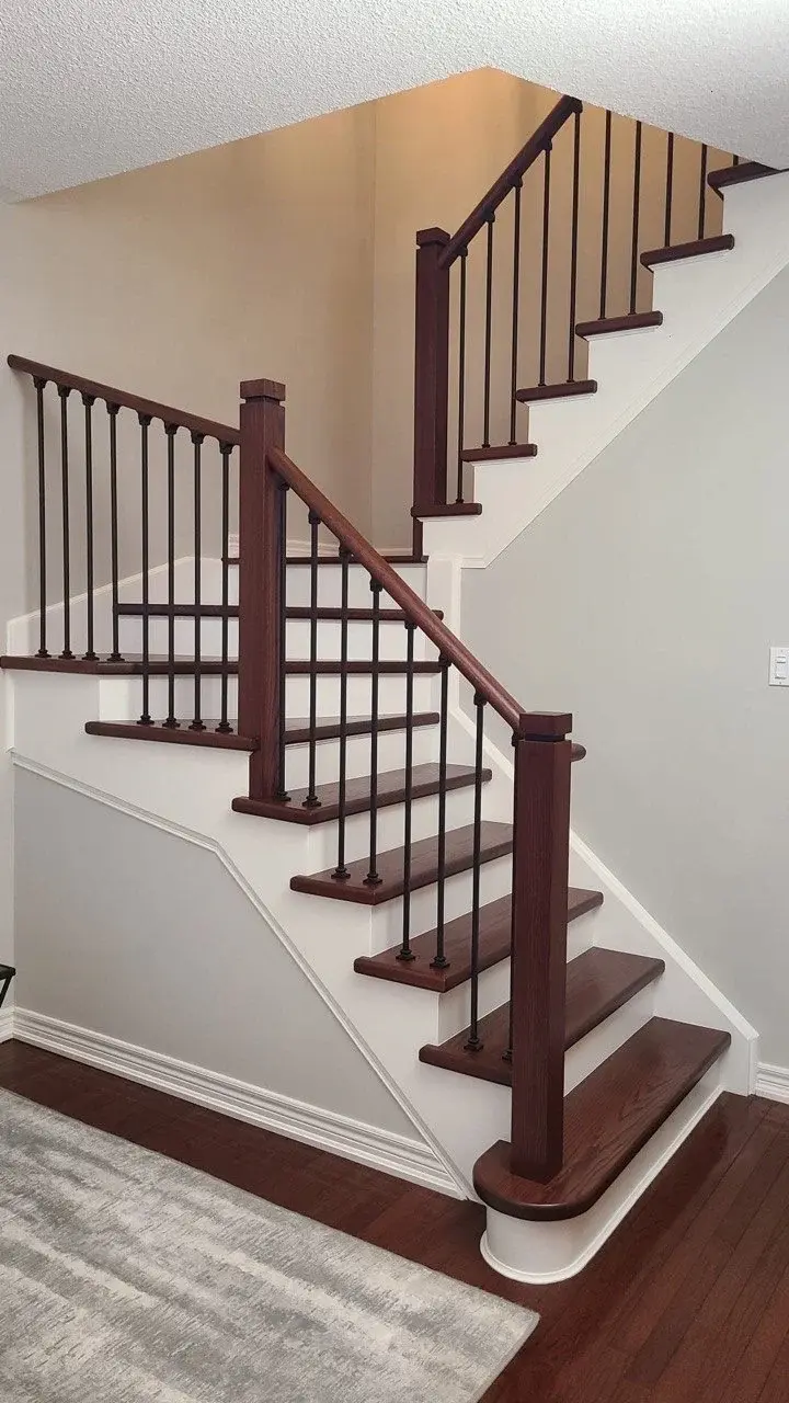 Full view of a multi-level staircase renovated with dark-stained wood and black metal railings.