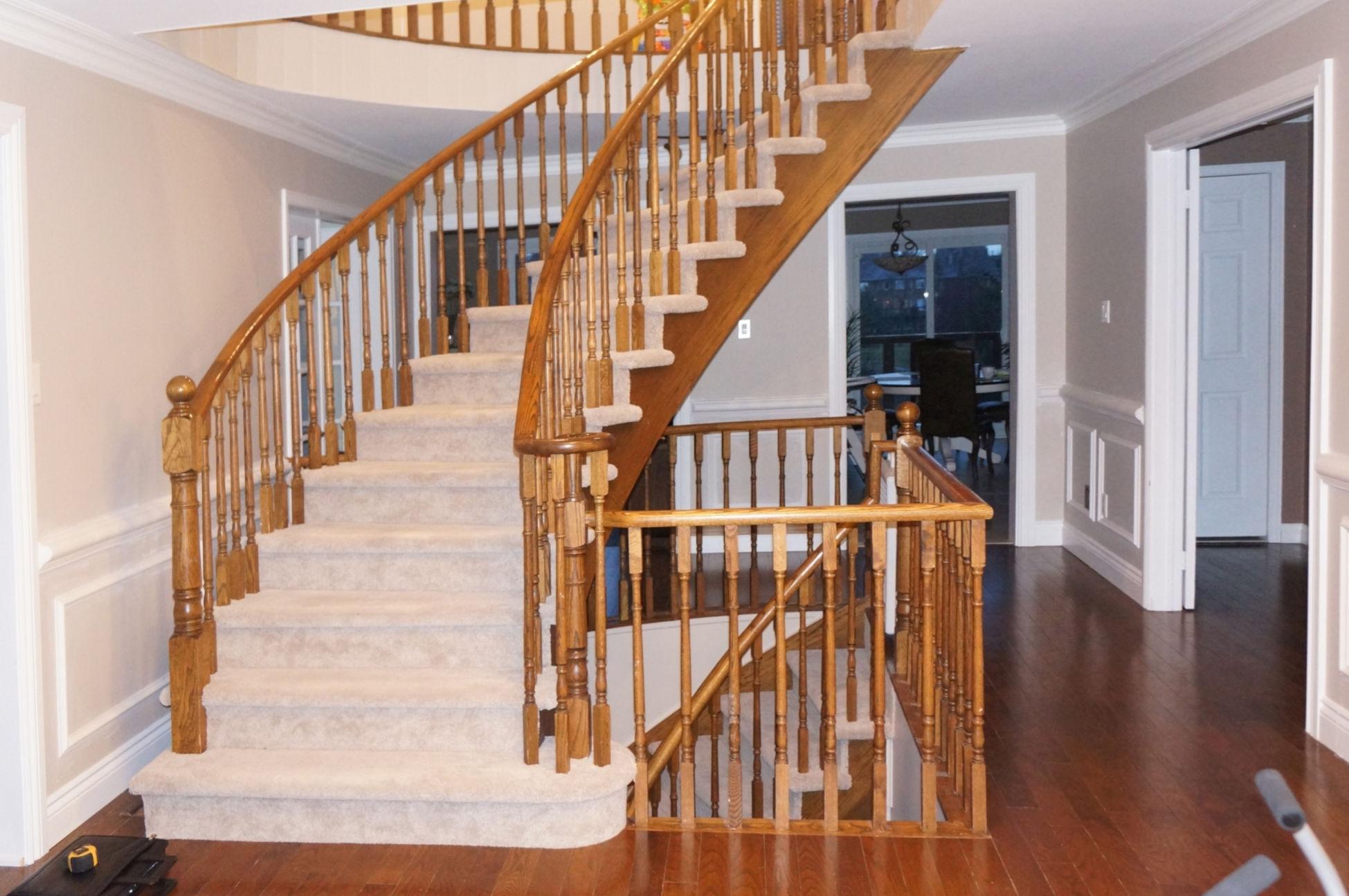 Carpeted staircase before hardwood tread-cap installation and railing updates.